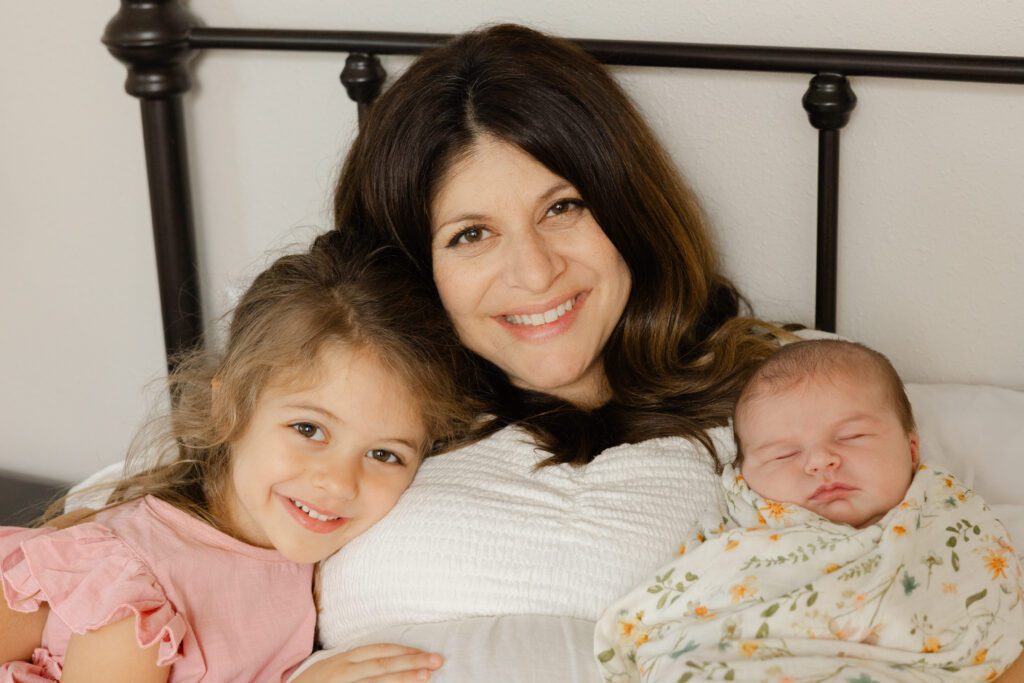 Portrait of newborn baby and big sister for their in-home newborn photography Portland shoot.