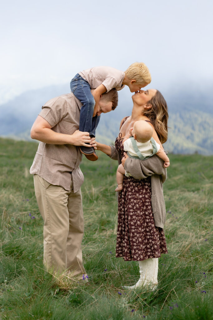 Candid family moment in the mountains with parents and two young children during family photos, Portland.