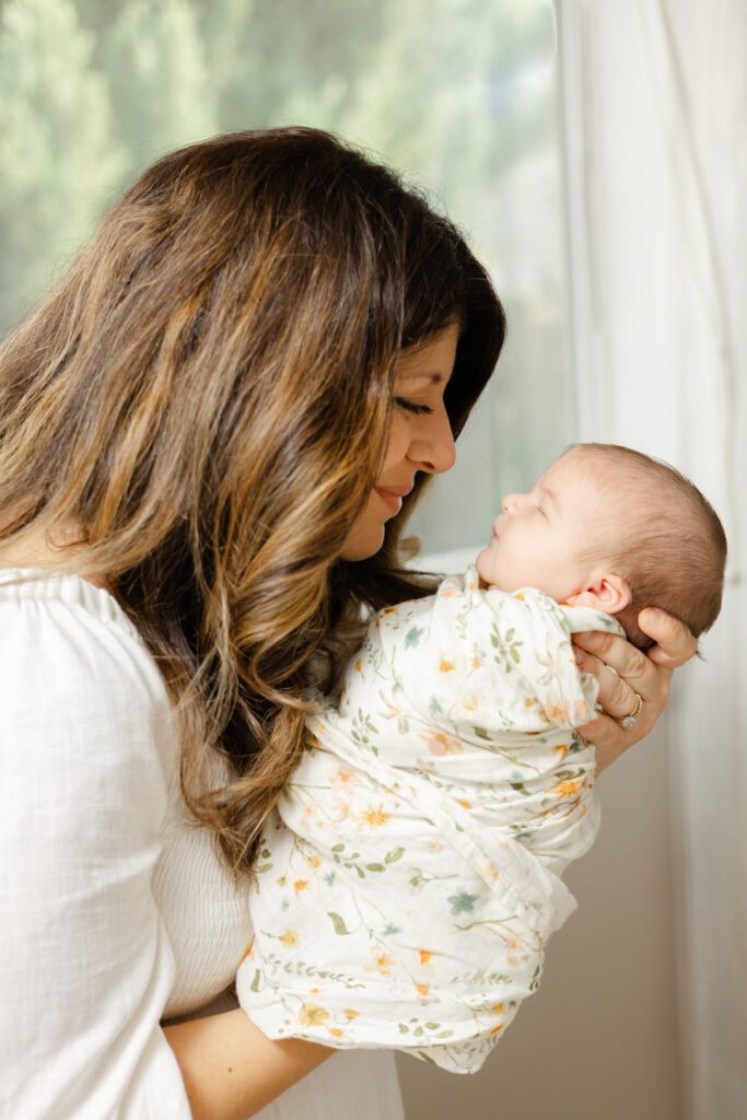 Mother and baby portrait near window for their newborn photography Portland session.