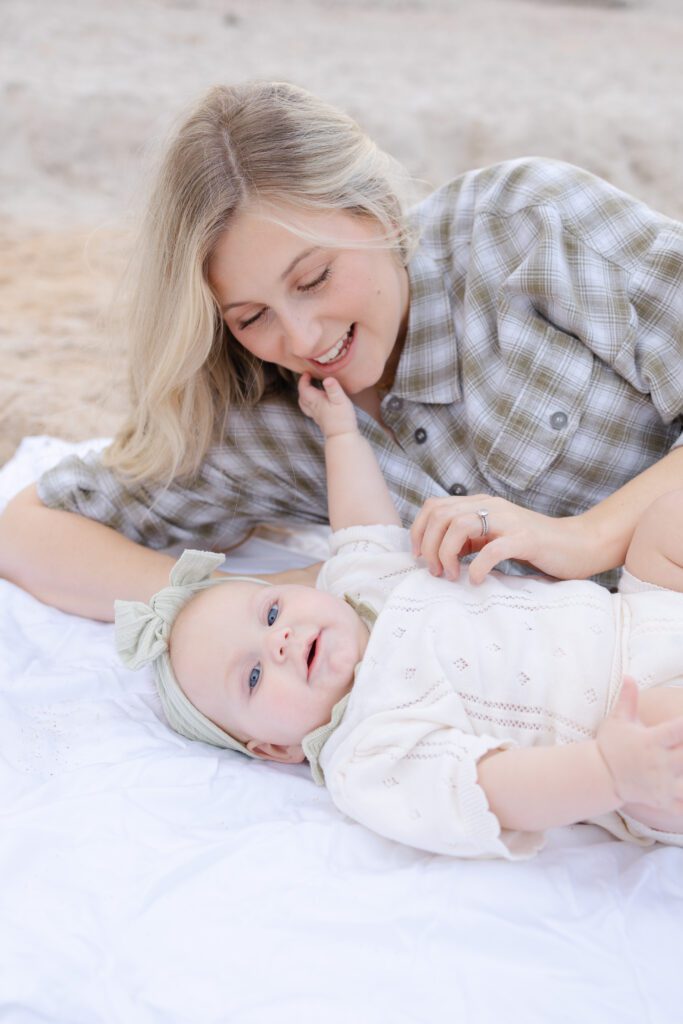 Mother and daughter relax on a blanket for a Portland lifestyle photographer's beach session.